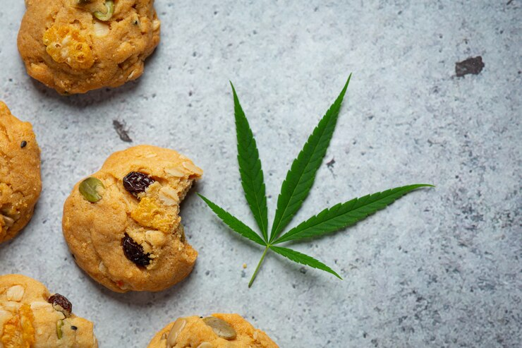 Cannabis-infused cookies with cannabis leaves arranged on the floor.